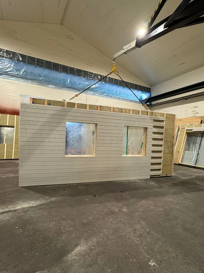 Prefabricerat väggelement lyfts med travers i husfabriken