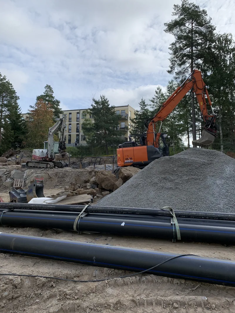 Markarbete med orange grävmaskin på Solnaprojekt